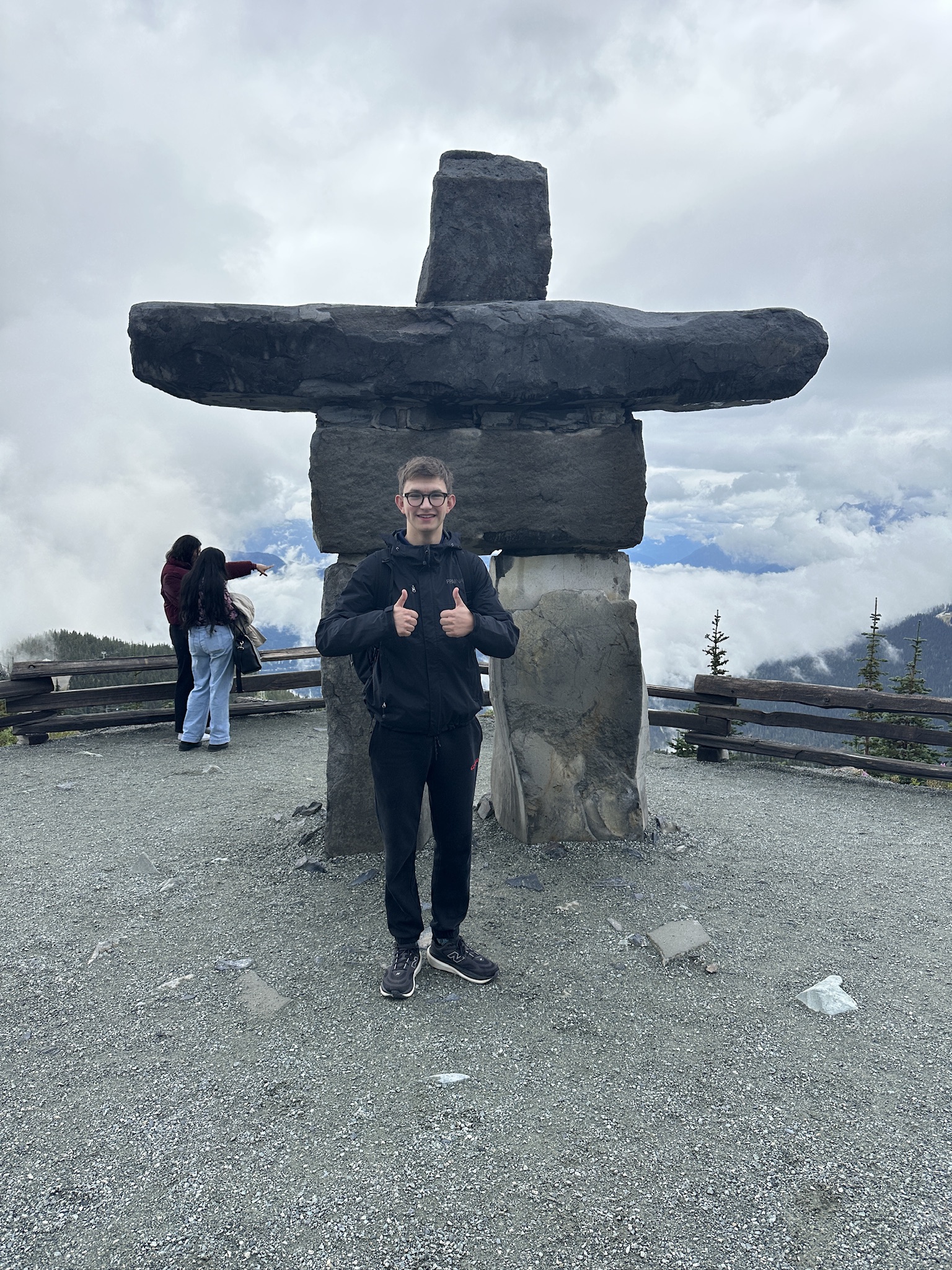 Noah Strauss outdoors beside a stone landmark